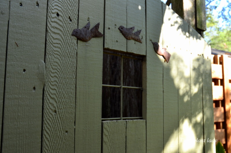 green garden gate with rusty birds