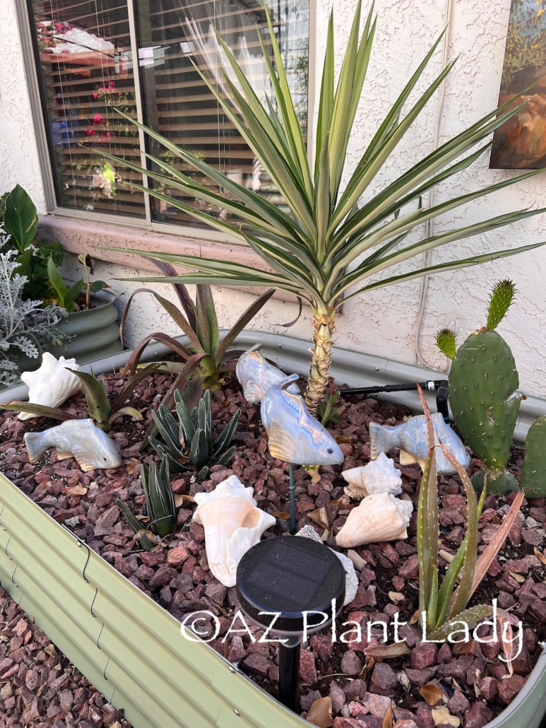 side yard art with ceramic fish and seashells